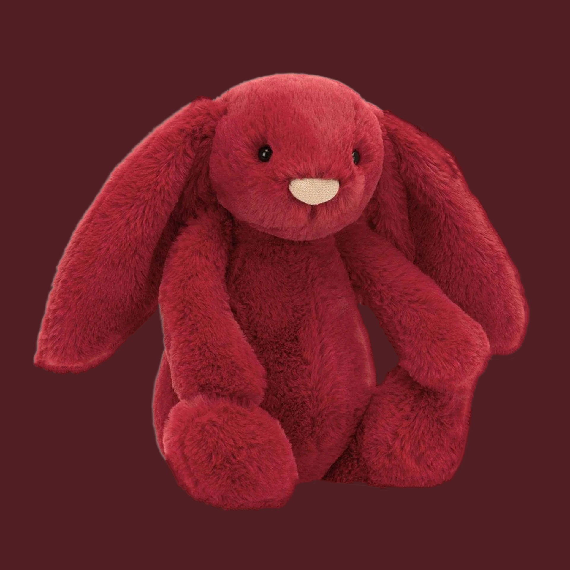 A red bunny stuffed animal toy. 