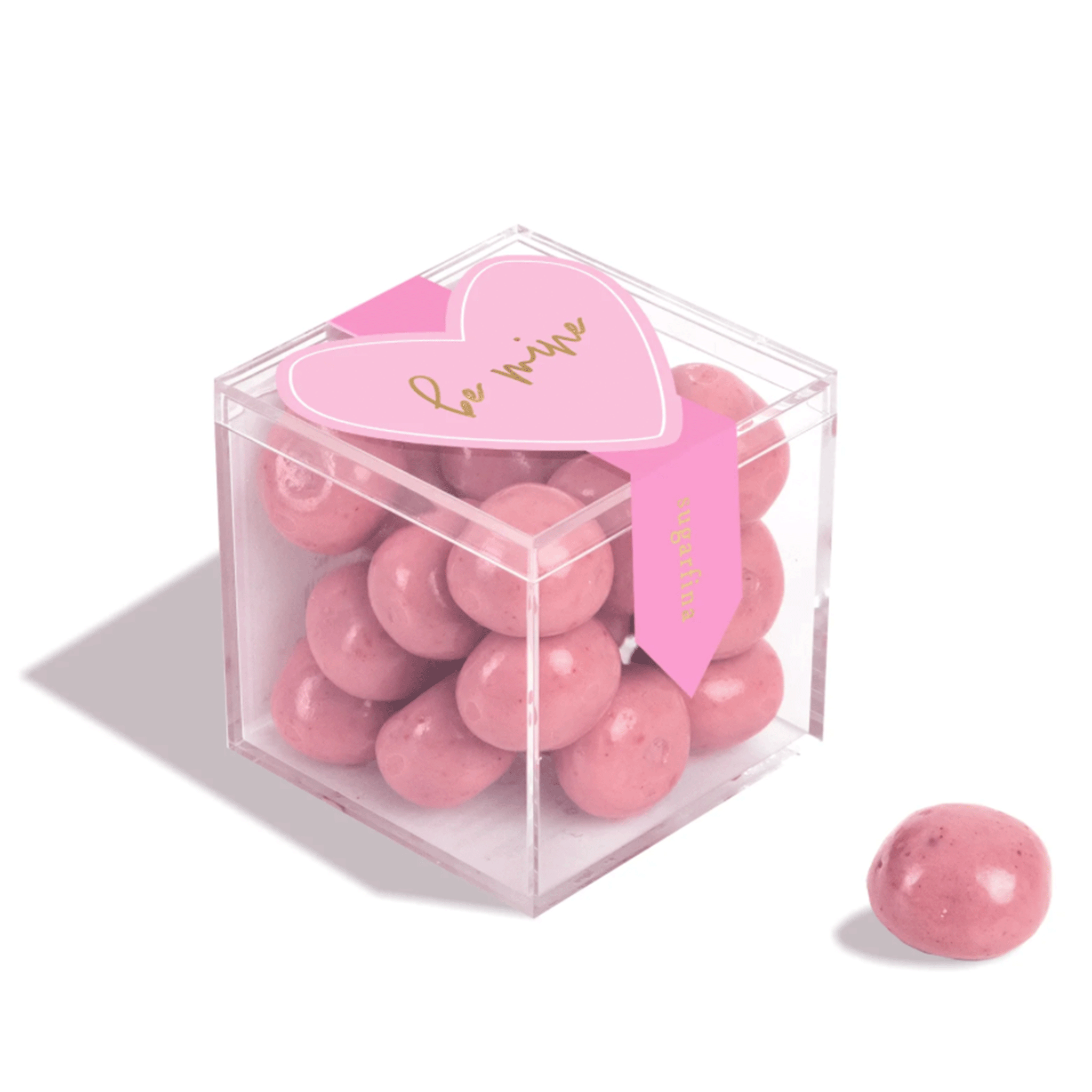 On a white background is a clear acrylic box filled with pink shortcake cookie candies. 
