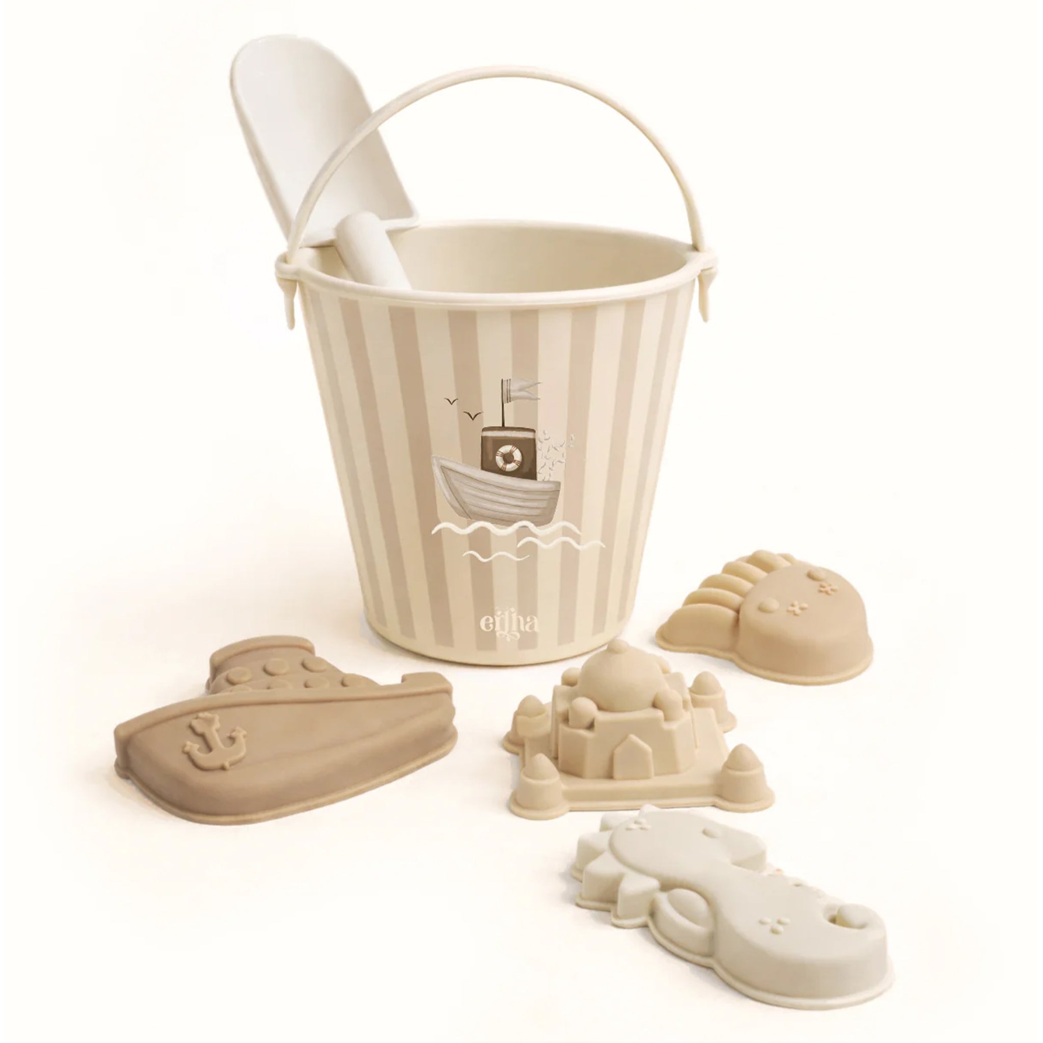Child playing with sand in a decorative bucket on a sandy surface