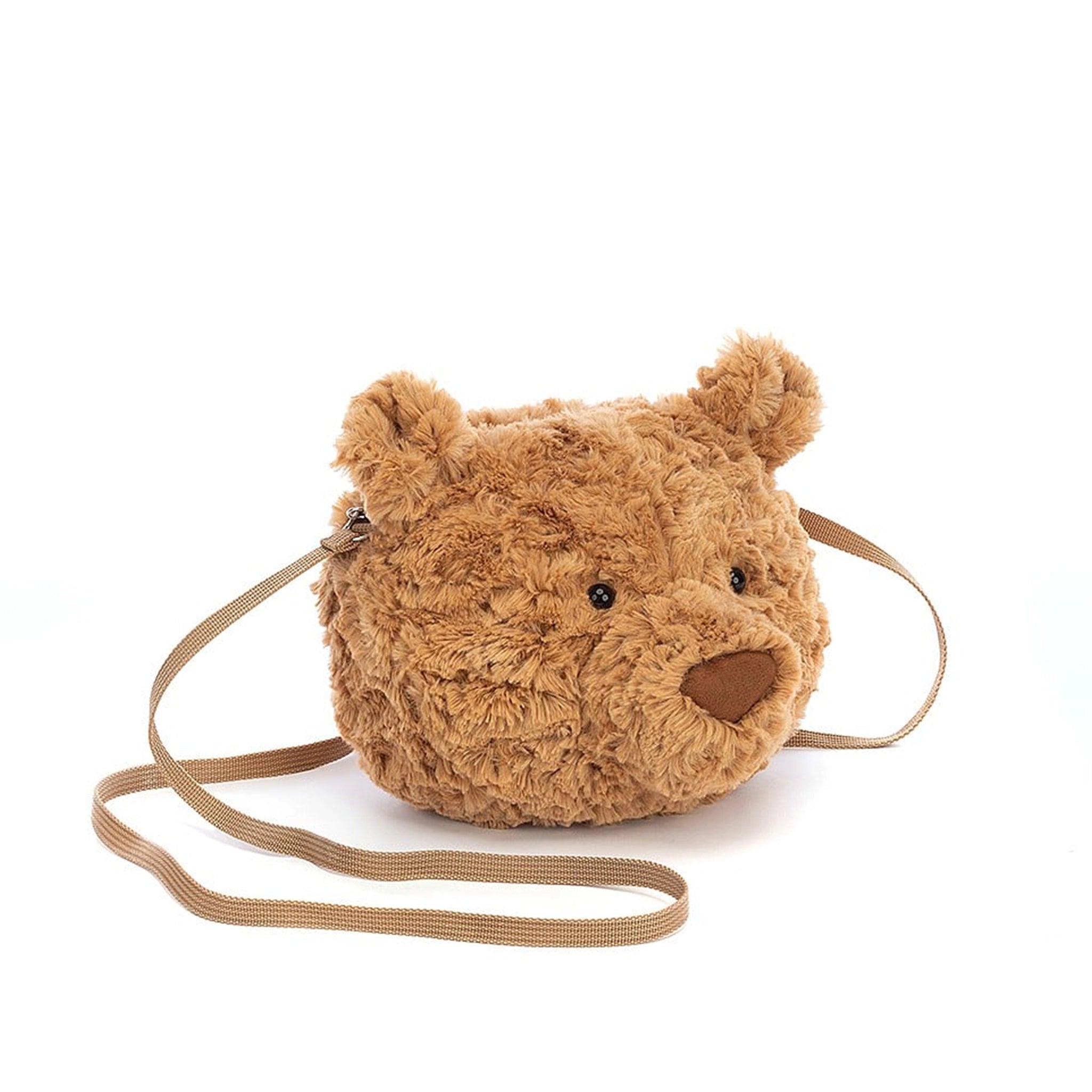 A stuffed animal bear head with a zipper opening and a brown strap for carrying. 