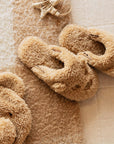 A pair of fuzzy brown slippers with a bear face design on the front. 