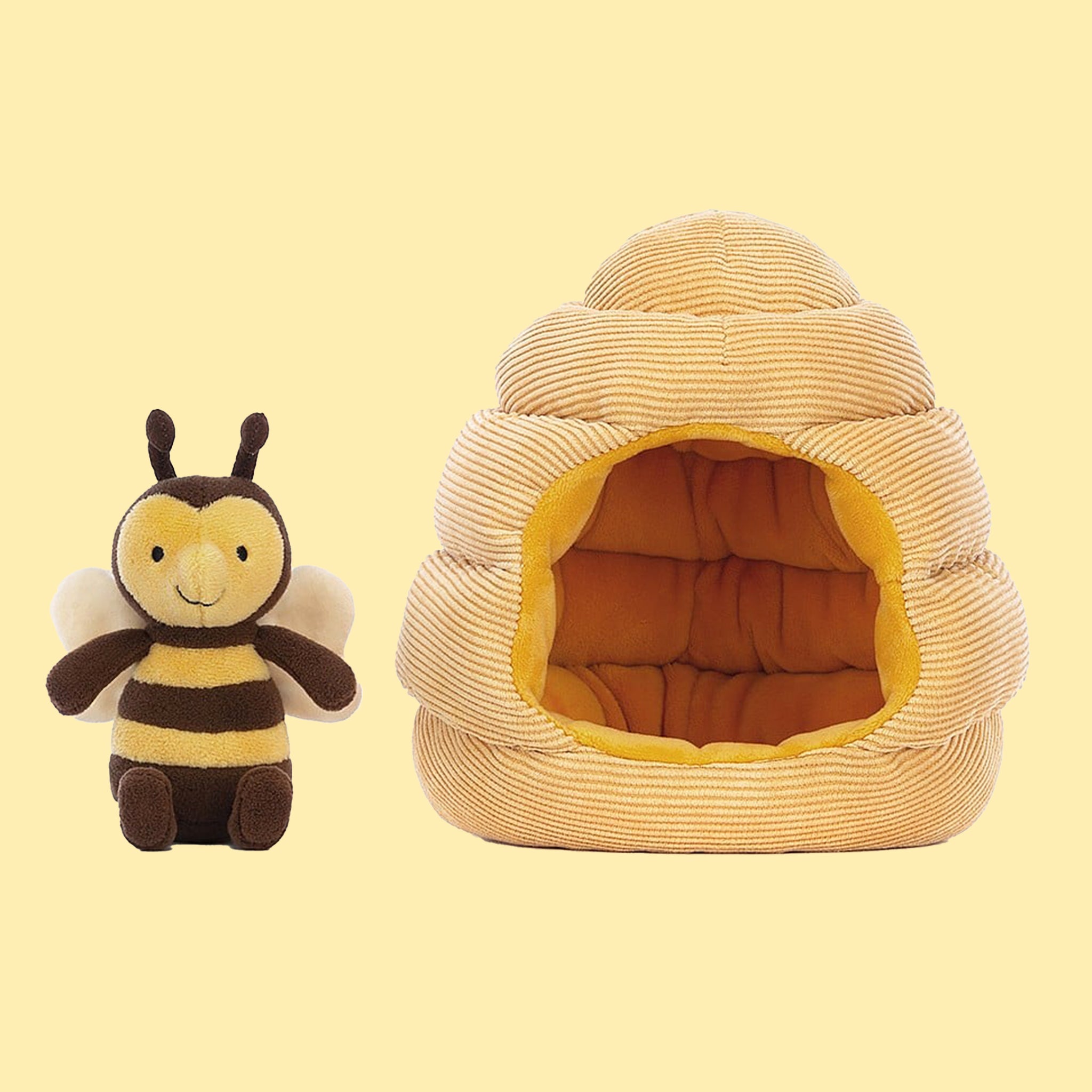 A bee shaped stuffed toy along with a honeybee hive shaped toy.