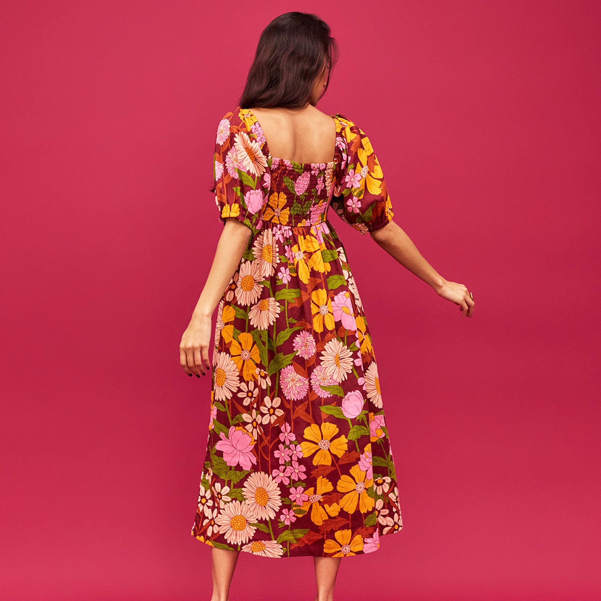 A mutli colored floral print maxi dress with puff sleeves and pockets.