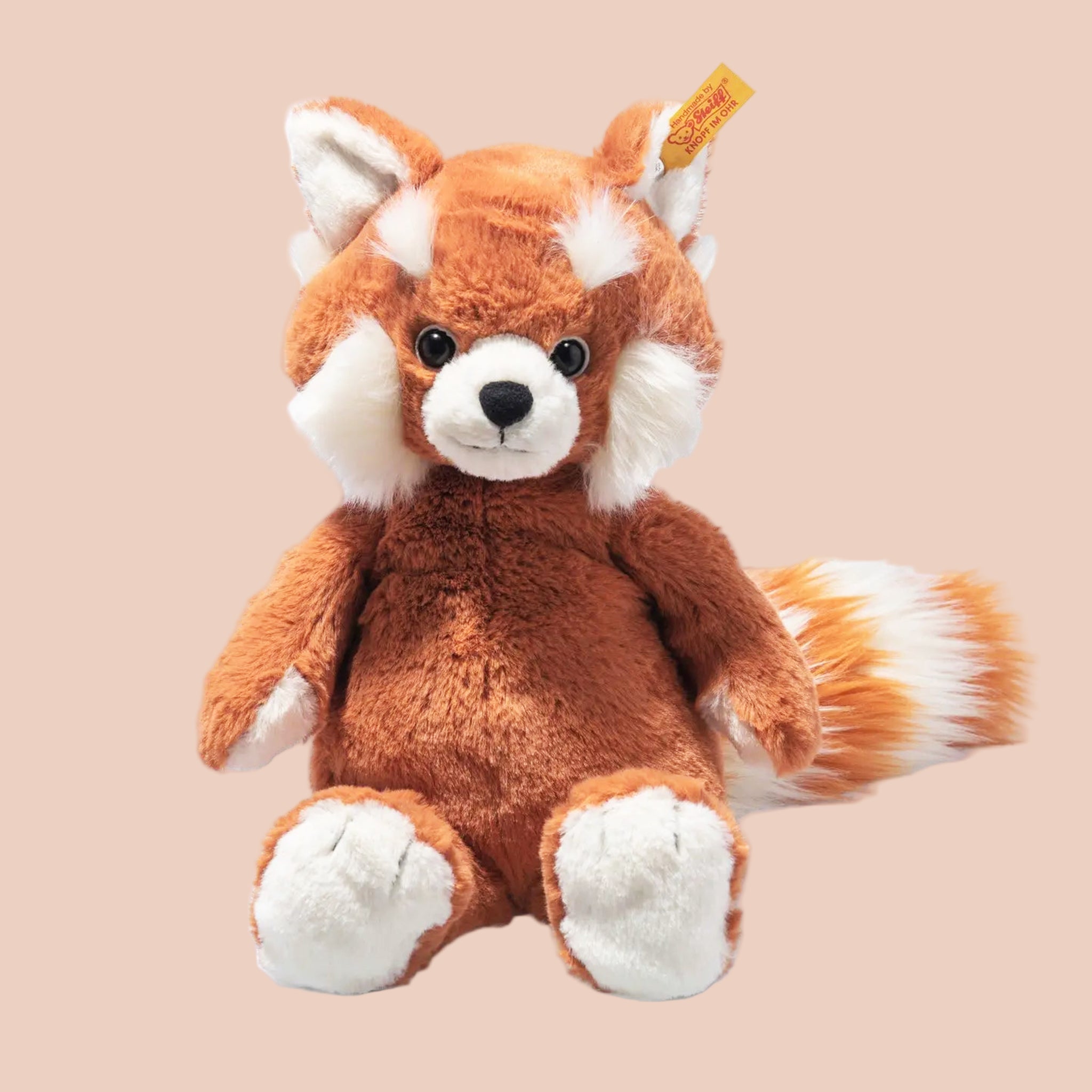 An orange red panda shaped stuffed animal toy. 