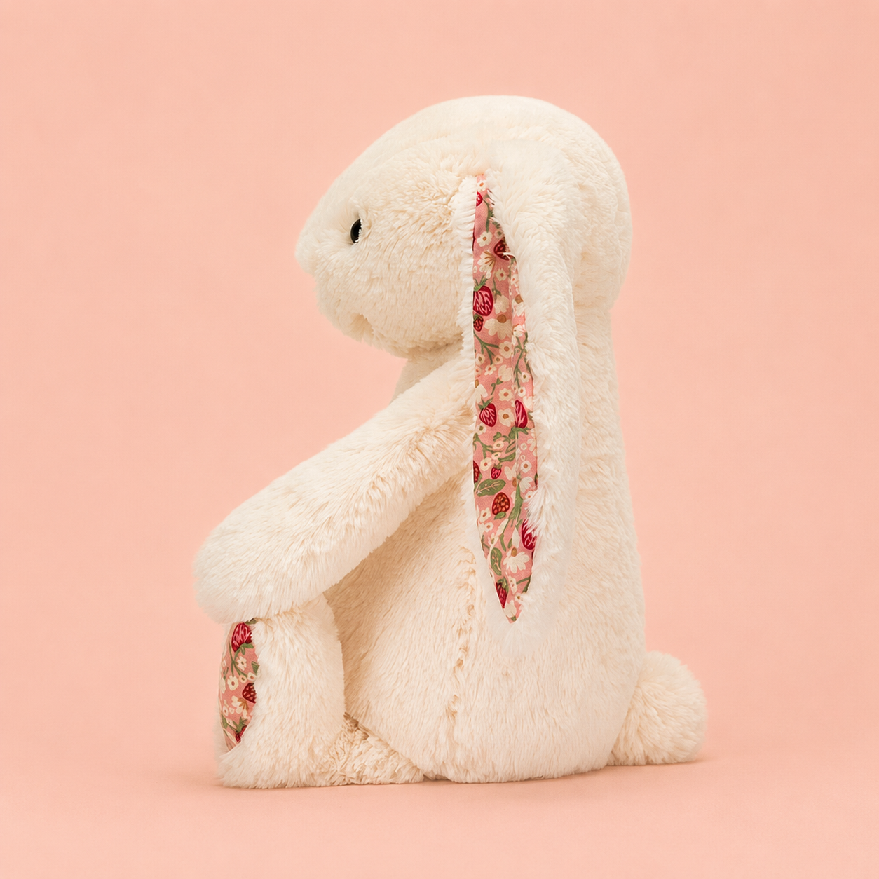a cream colored plush bunny toy with strawberry pink ears and feet. 