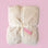A white fur blanket with a satin ribbon and a pink tag that reads "bestie" tied onto it.