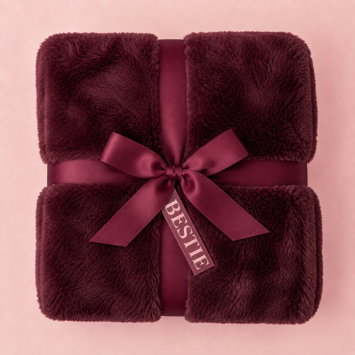 A ruby colored fur blanket with a tag that reads "bestie"