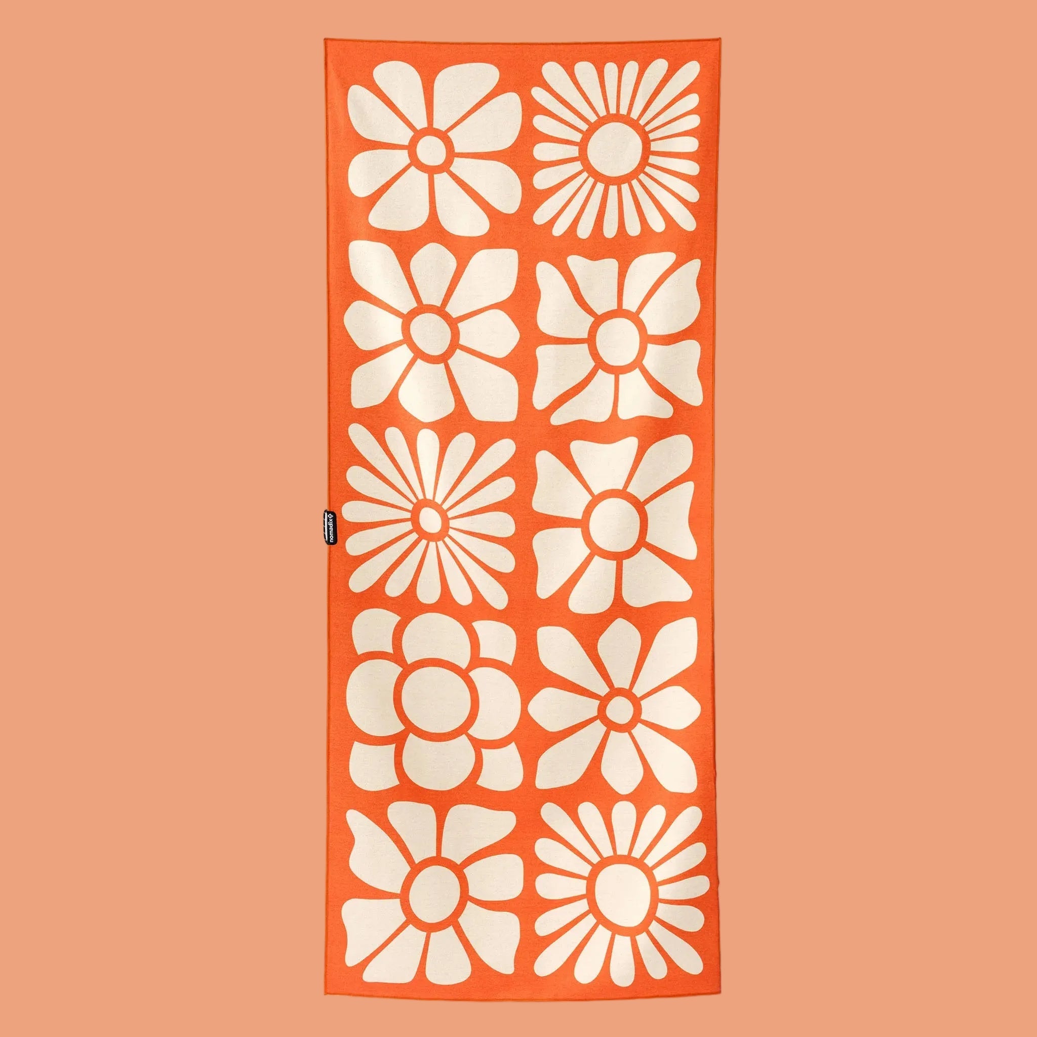 An orange towel with white floral pattern. 