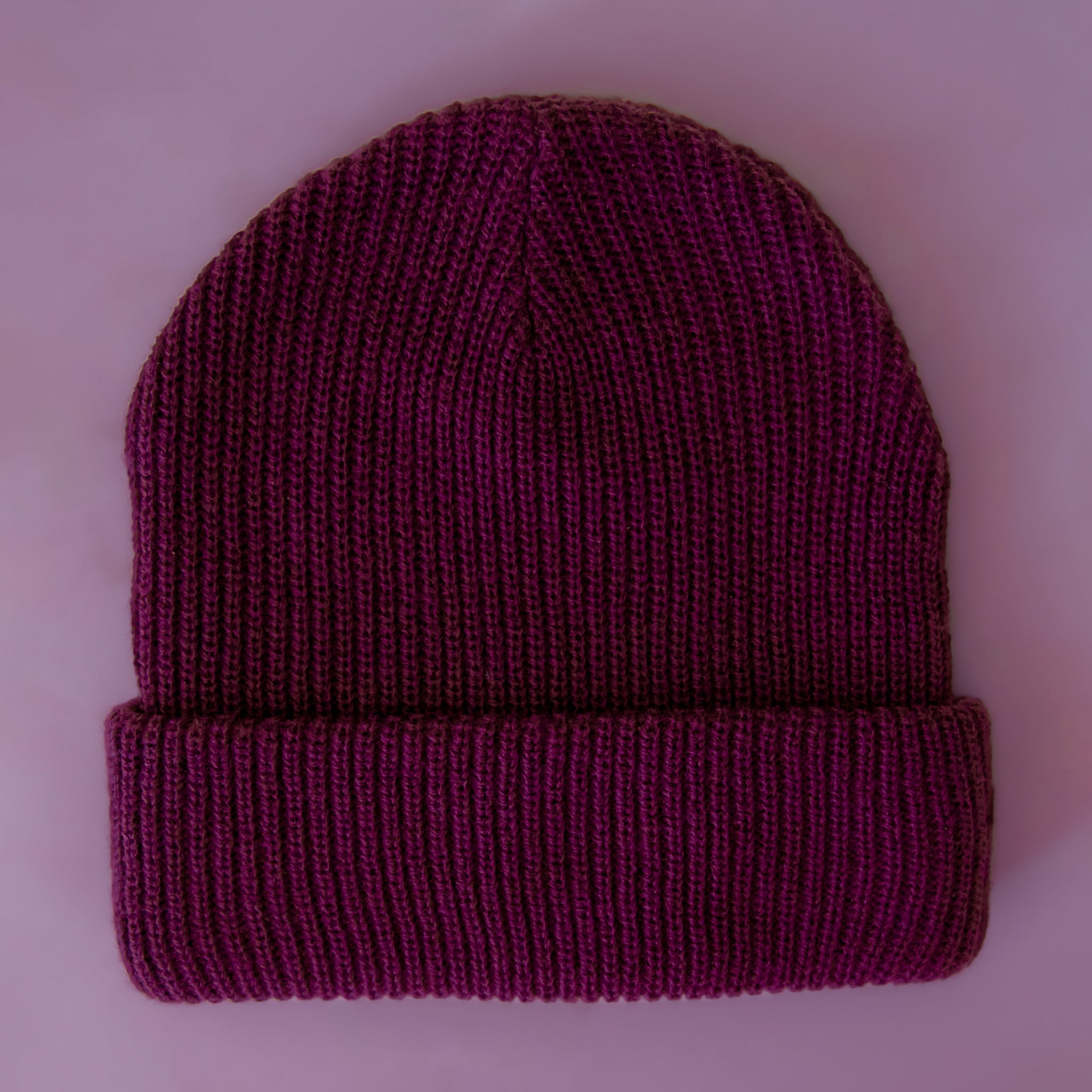 A dark purple ribbed beanie. 