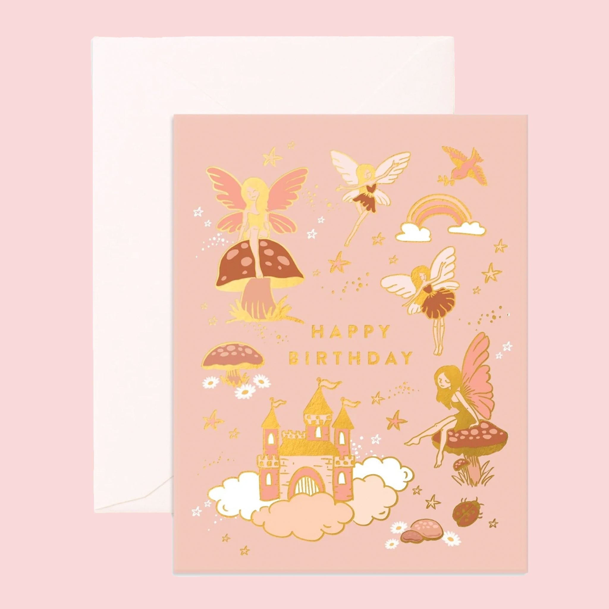 A peachy pink birthday card with gold foiled fairy illustrations and a castle and gold text that reads, "Happy Birthday". 