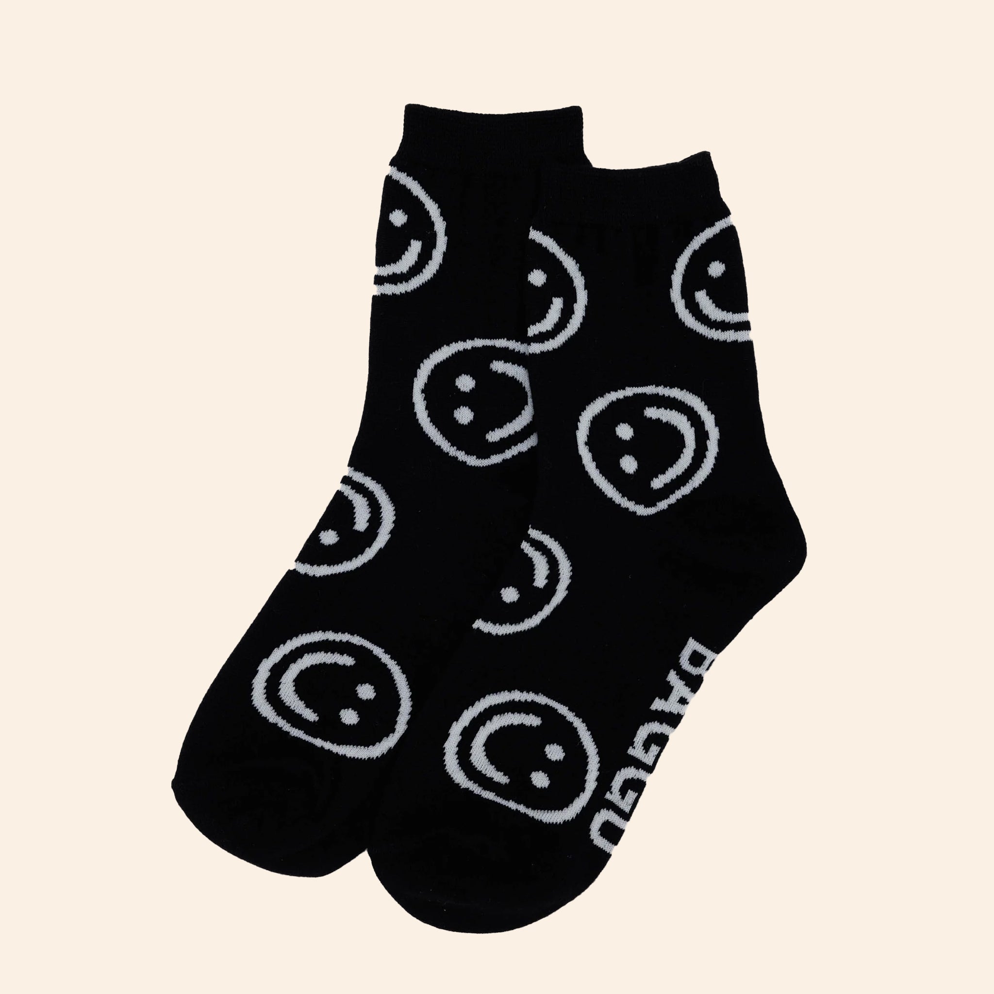 A pair of black socks with white smiley faces on them. 