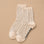 A pair of cream and black micro polka dot socks.