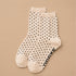 A pair of cream and black micro polka dot socks.