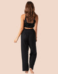 A model wearing a pair of black cotton wide leg pants with an elastic waistband. 