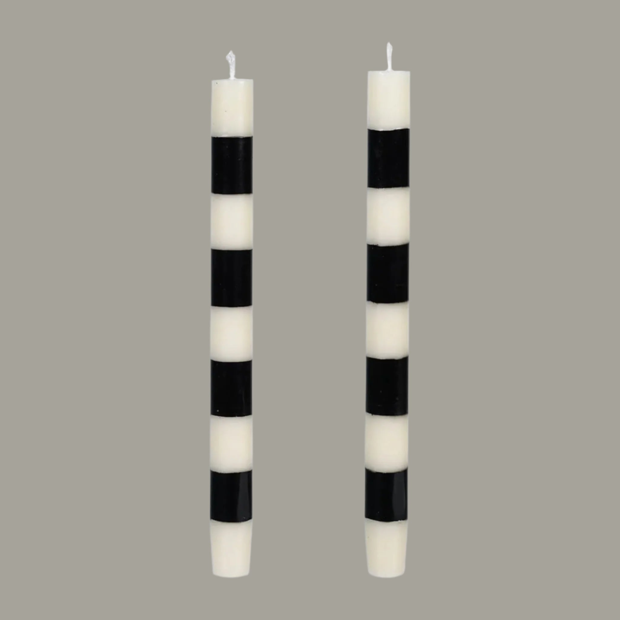 A set of ivory and black horizontal striped taper candles. 