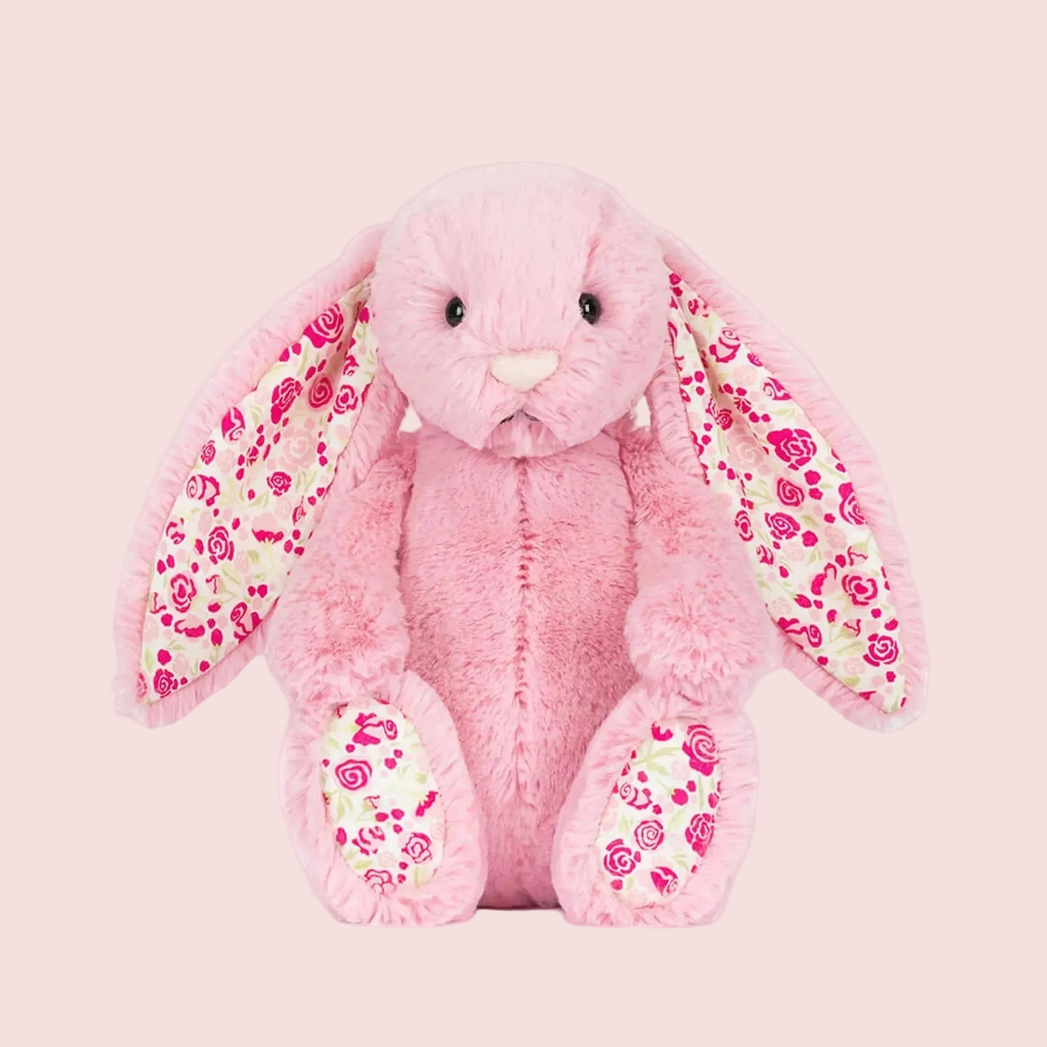 A pink bunny shaped stuffed animal.  
