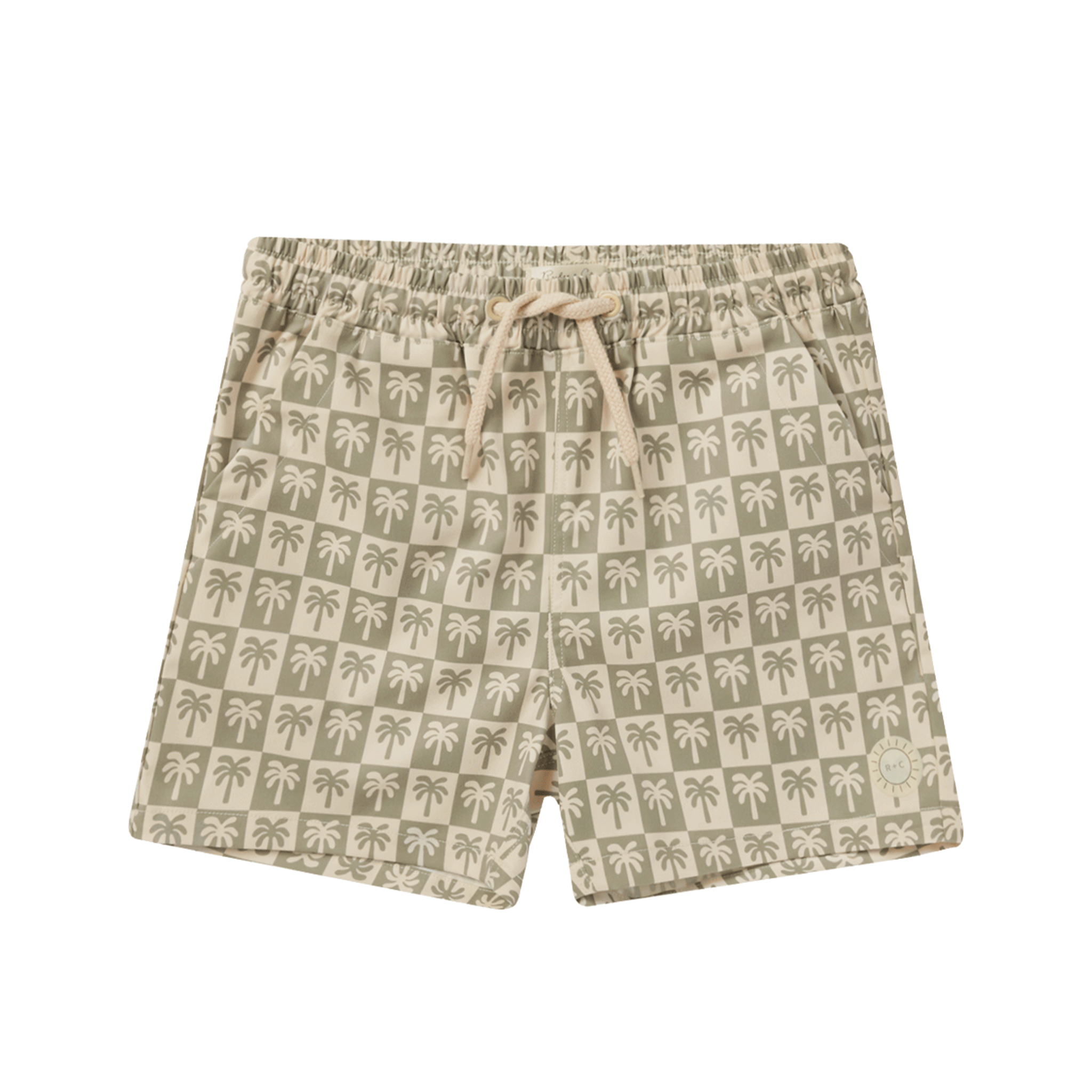 On a white background is a pair of children's swim shorts with an ivory drawstring and sage and palm tree checker print. 