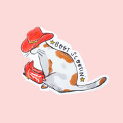 A sticker in the shape of a cat with a red cowboy hat and red cowboy boots on with black text that reads, 'Boot Scootin'. 