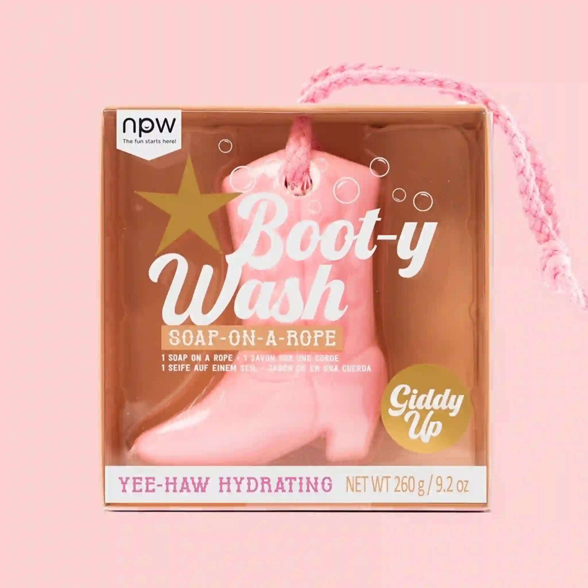 On a pink background is a pink boot shaped soap in a cardboard container.