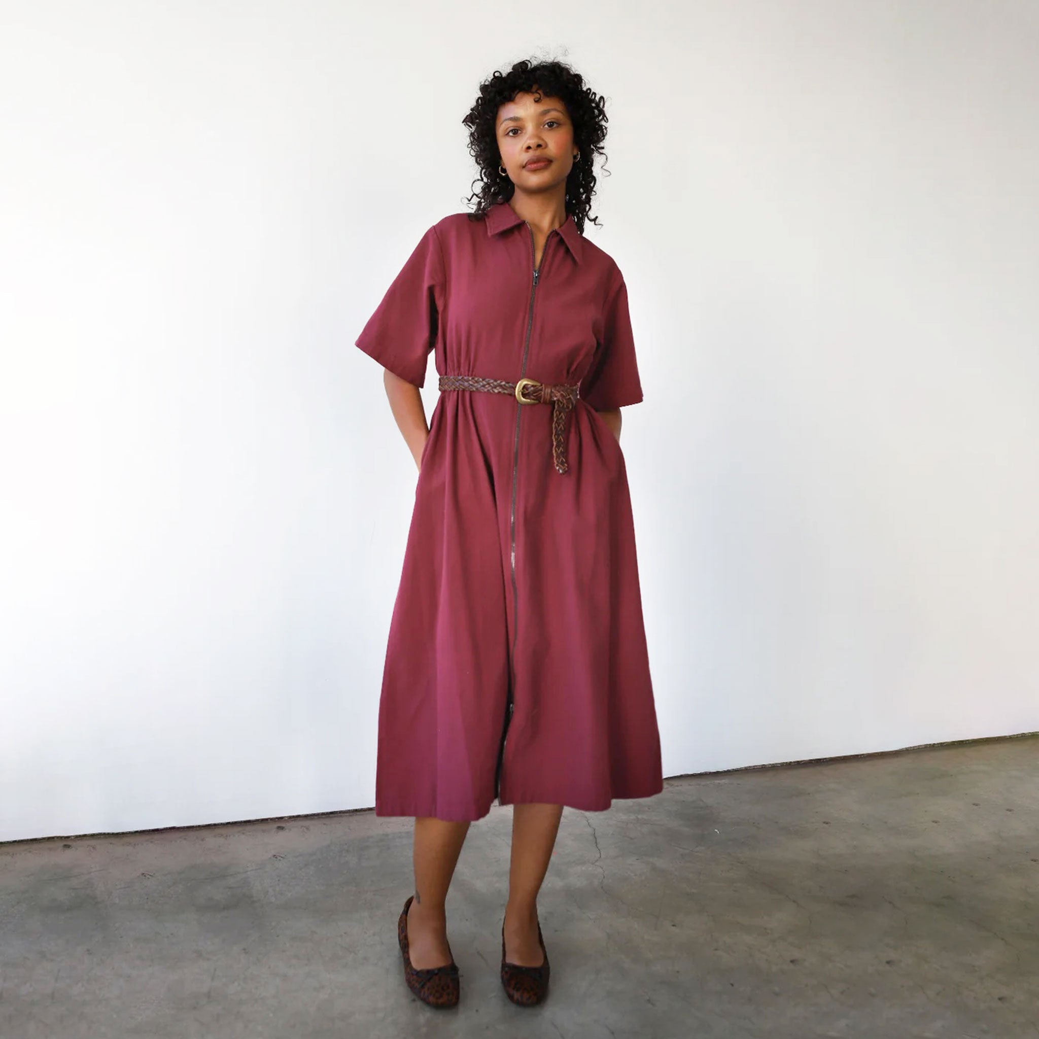 A long dark red zipper dress with a collar and short sleeves. 