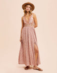 A dusty pink floral maxi dress with a v-neckline and a small slit at the bottom. 