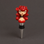 A novelty wine bottle stopper featuring a stylized pin-up doll head with bright red hair, horns, and a red top, mounted on a black rubber seal and silver metal spike against a dark gray background.
