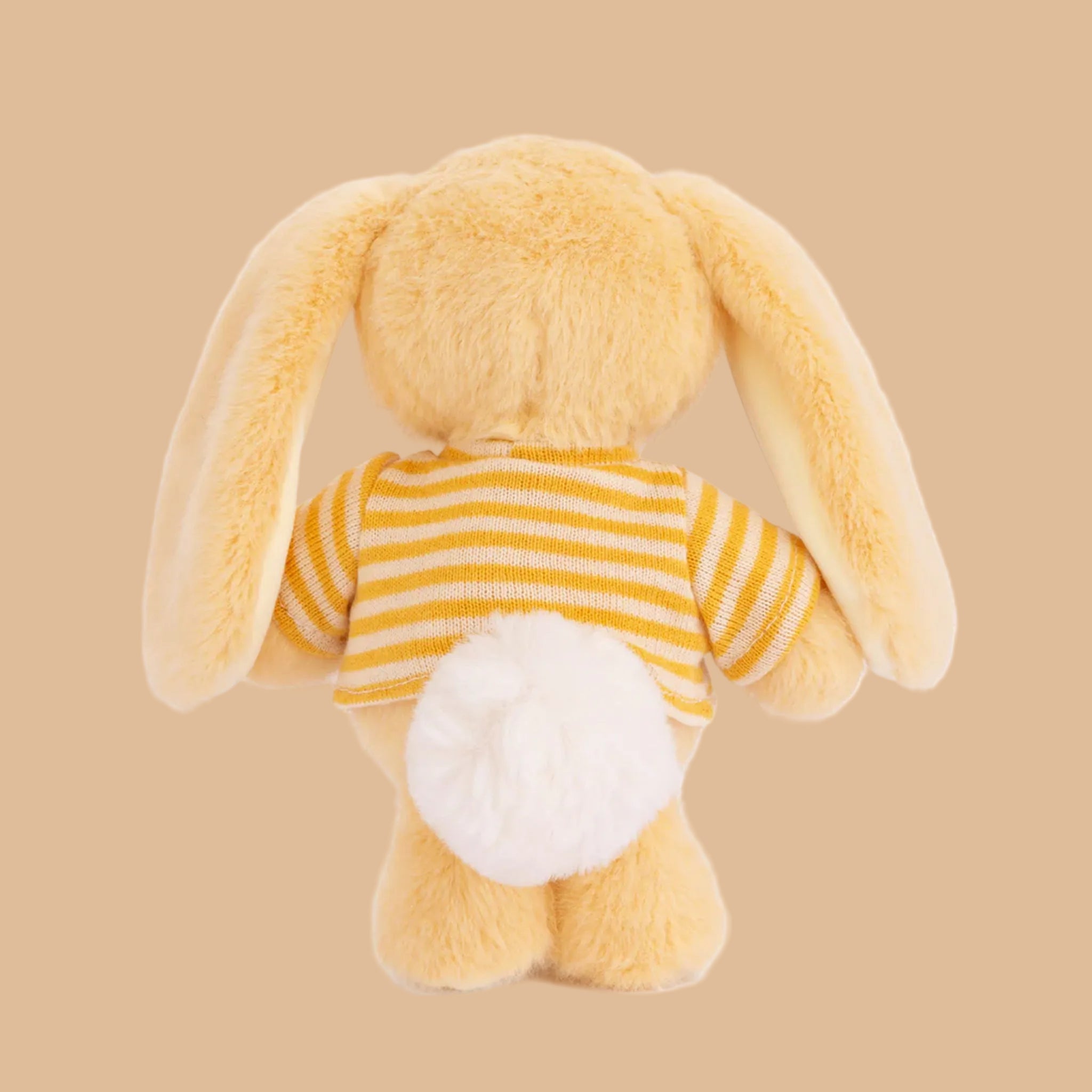 A yellow bunny shaped stuffed toy with a striped shirt. 