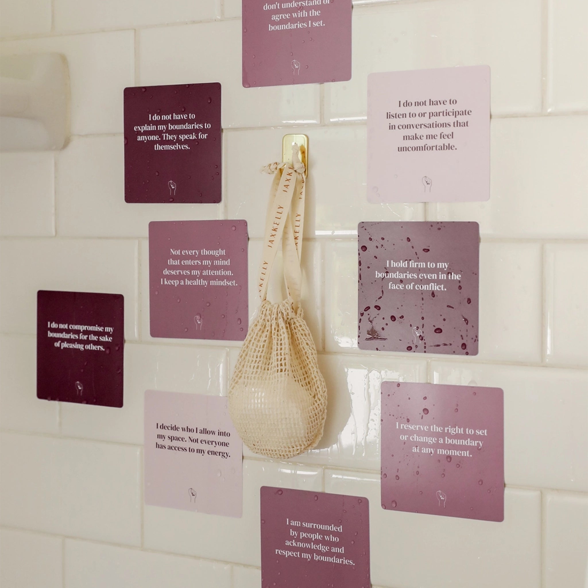 Various shades of purple waterproof cards with have affirmation quotes on each one related to healthy boundaries along with a shower steamer.