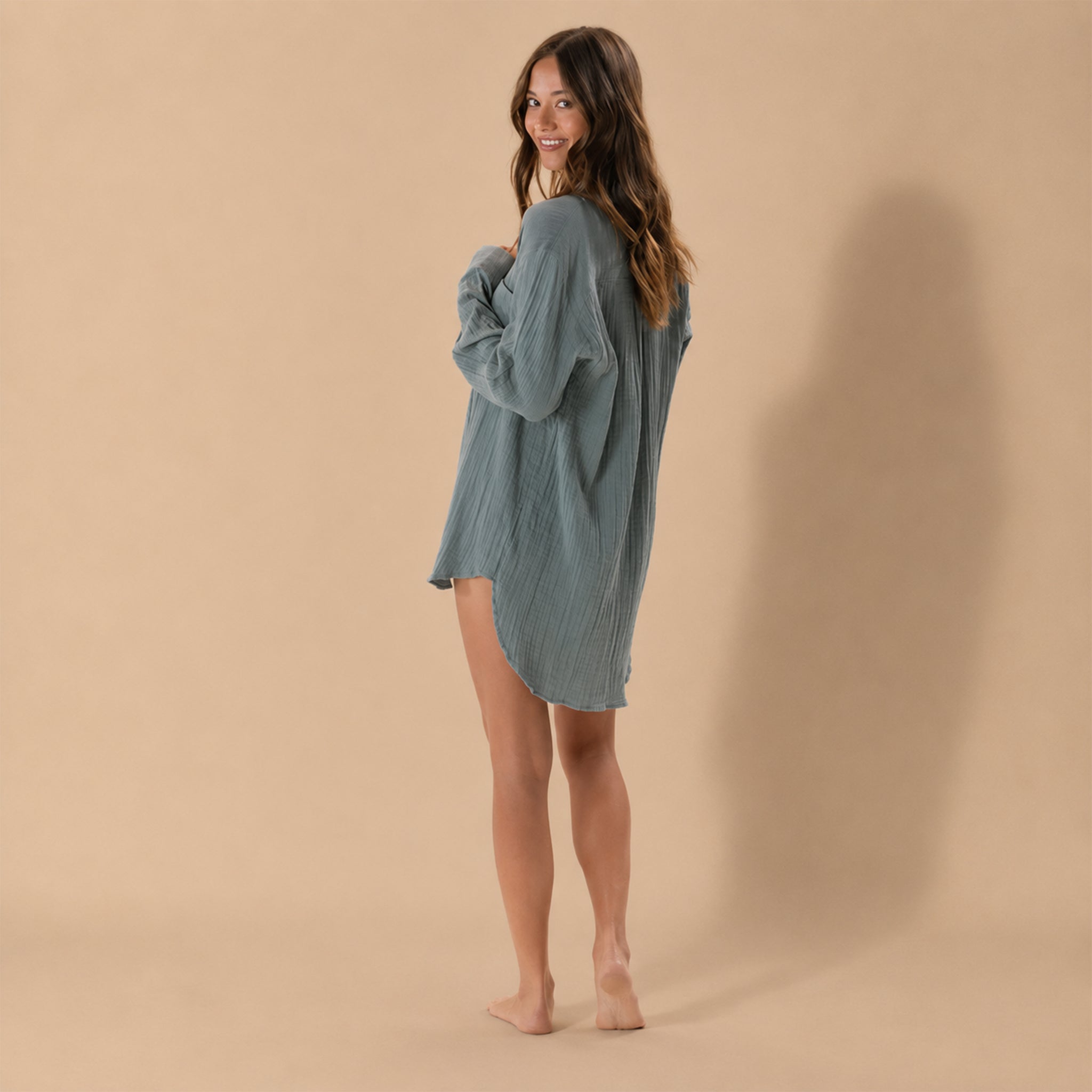 Model wearing an oversized button up shirt. 
