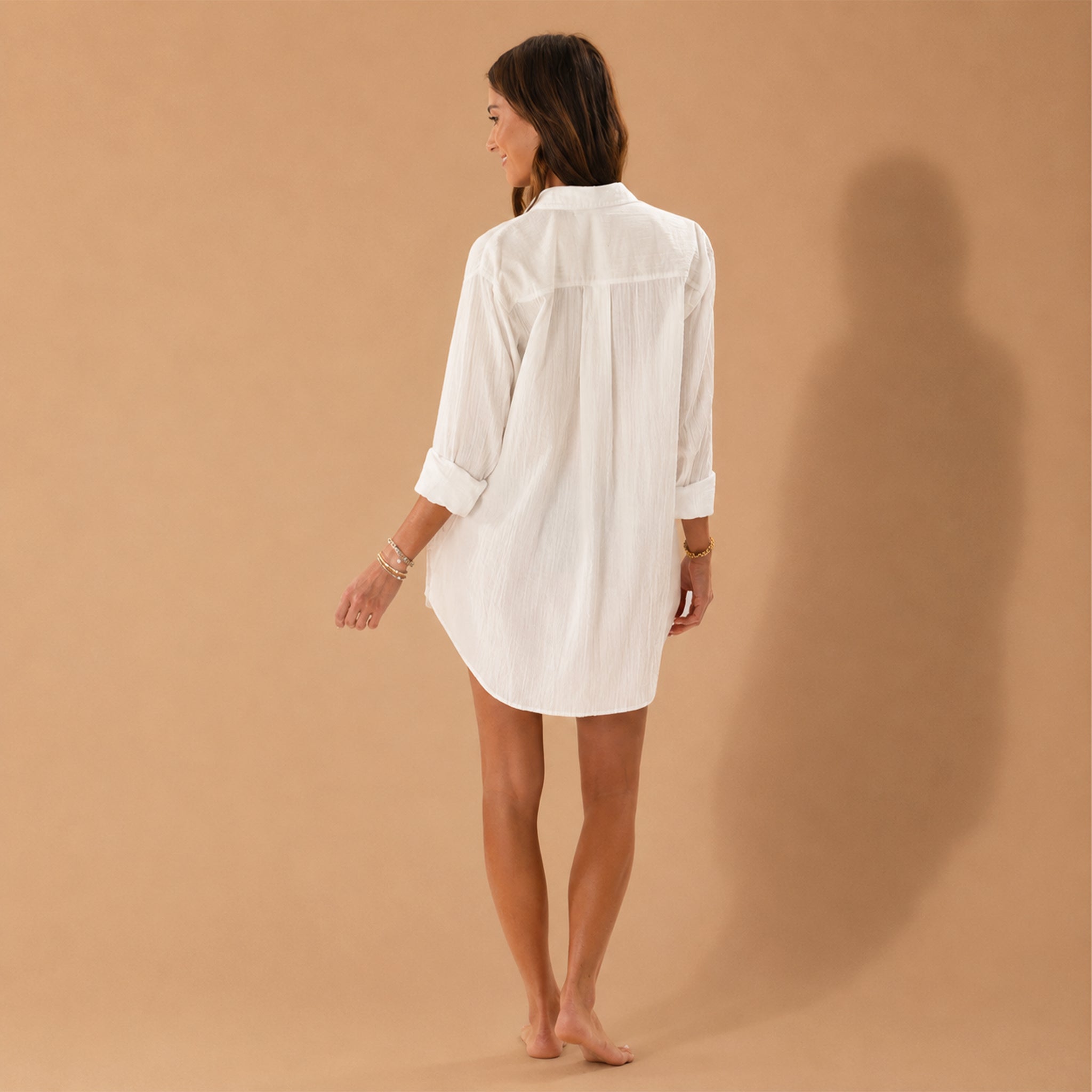 A model wearing a white button up long sleeve shirt. 