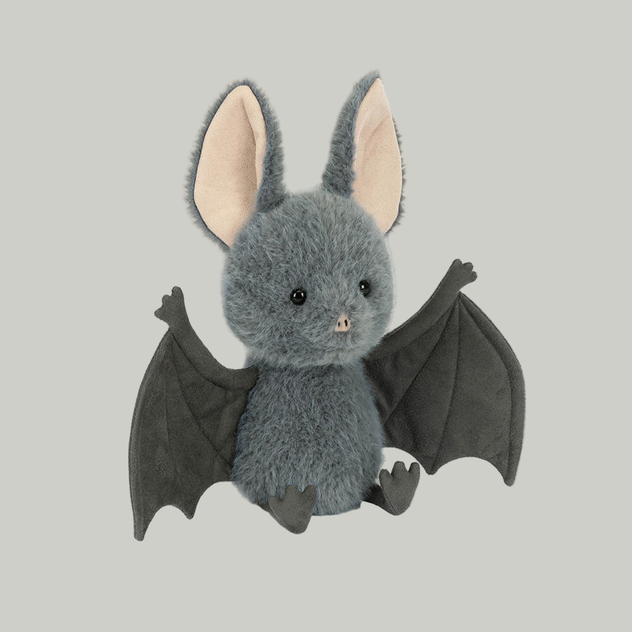 A grey bat shaped stuffed animal toy. 