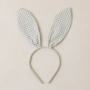 A bunny ear shaped headband with a light sage and cream checker print. 