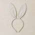A bunny ear shaped headband with a light blue and cream stripe pattern. 