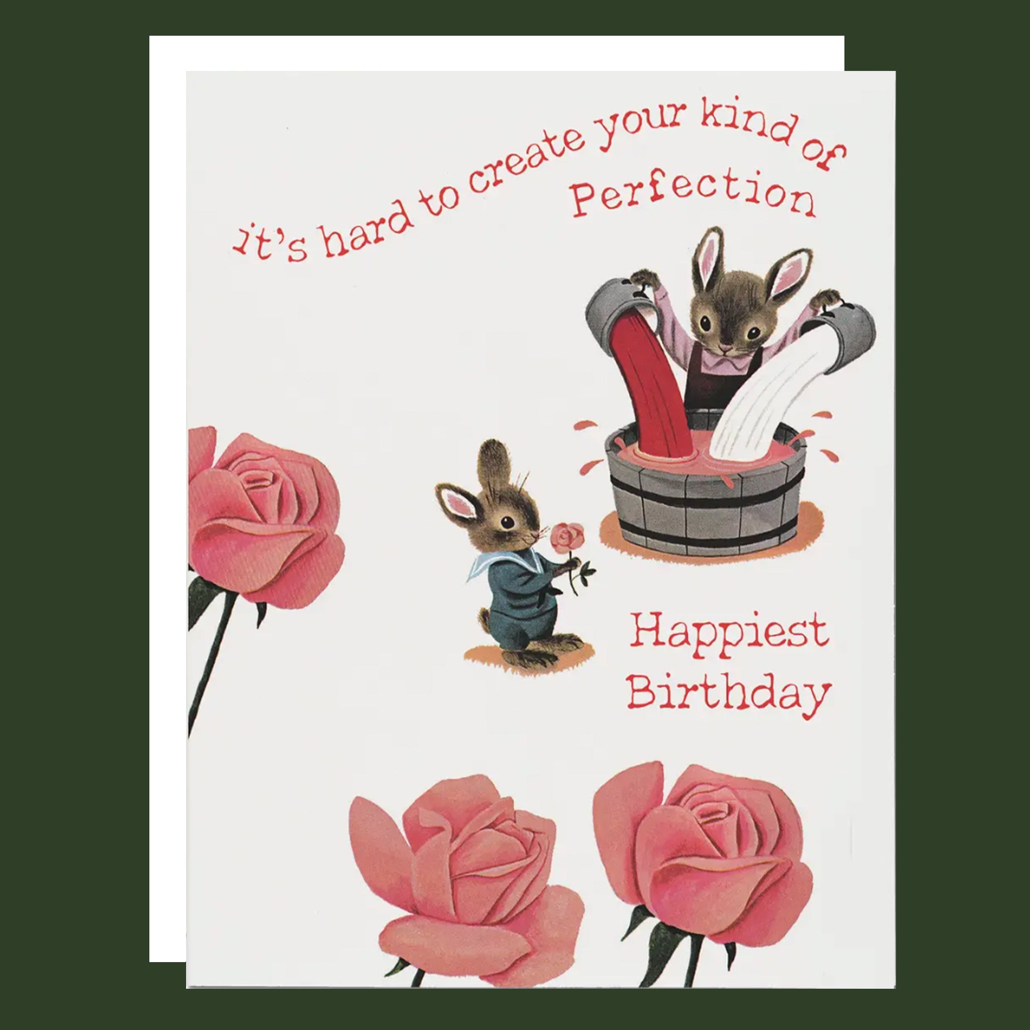 A square greeting card with a white background and whimsical illustration of rabbits, roses, and red text reading 'it's hard to create your kind of Perfection' and 'Happiest Birthday.' A second card is partially visible behind it on a dark green background.