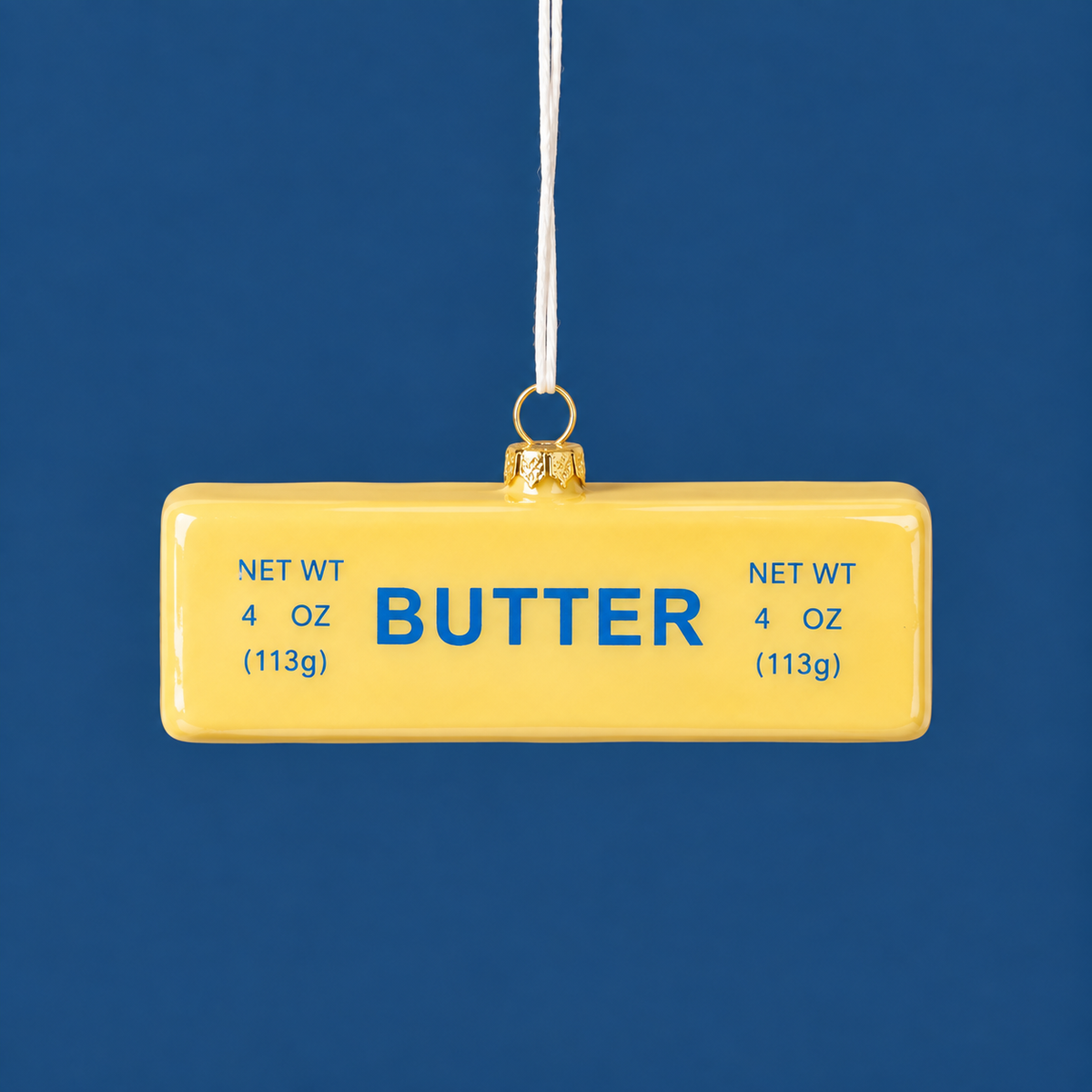 A yellow stick of butter shaped ornament with blue text that reads "butter"