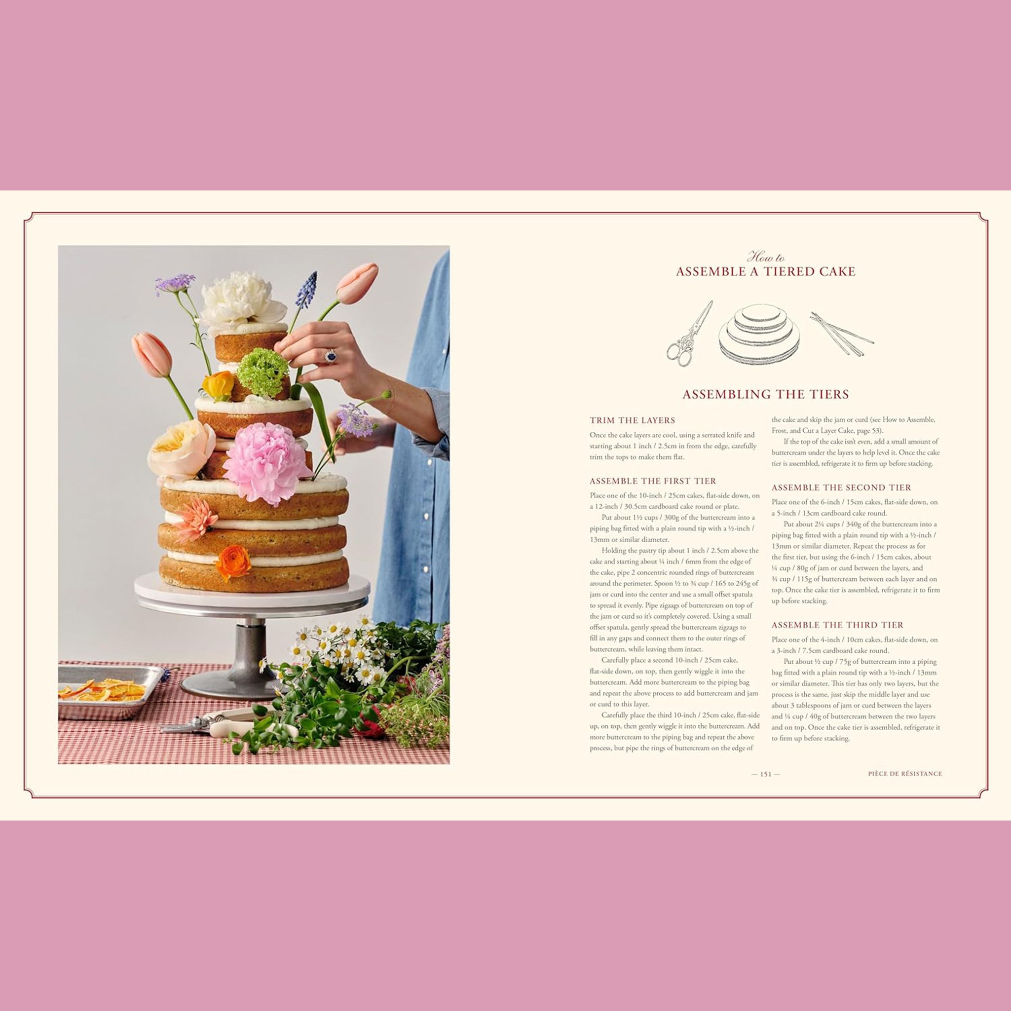 The interior of a cook book featuring a layered cake with flowers being stuck in it.  The right side of the open page reads "assemble a tiered cake" and walks you through the process.