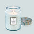 A blue glass candle sits in the middle of image.  The label on the candle reads, "Voluspa California Summers"