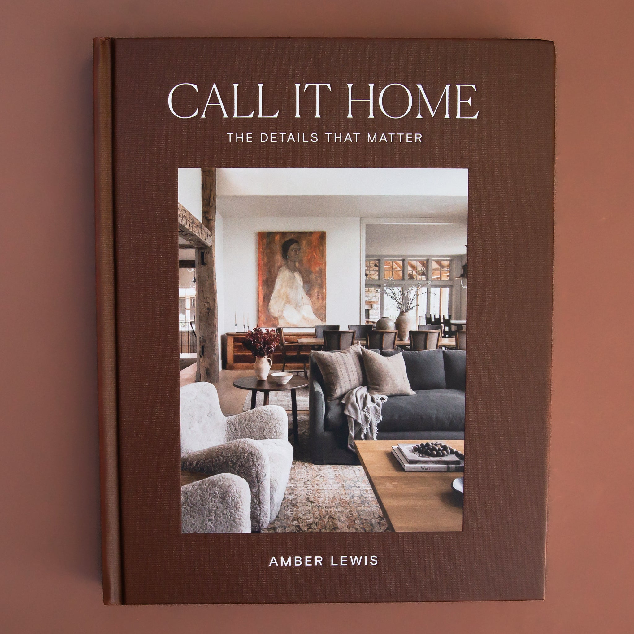 On a brown background is a brown book cover with a photo of a curated interior design space with white text at the top that reads, "Call It Home The Details That Matter". 