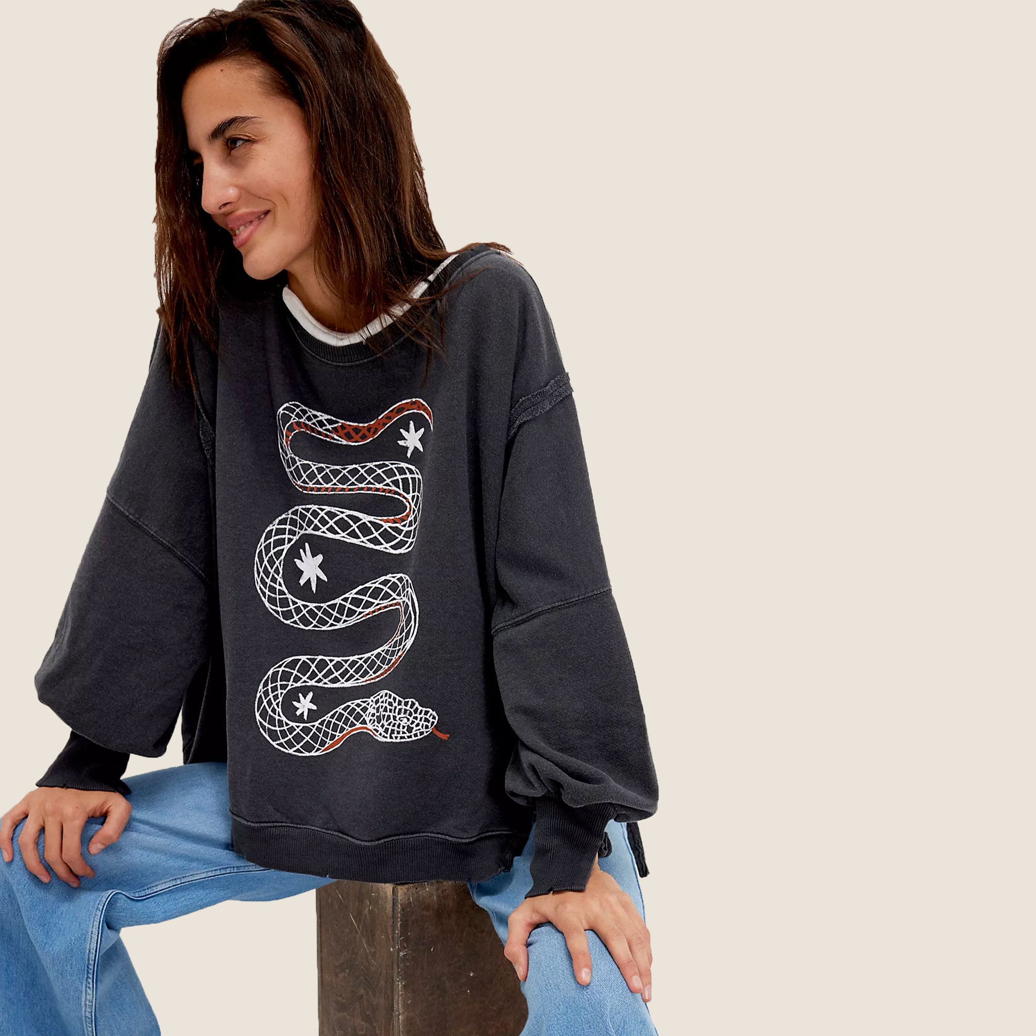 A grey slouchy sweatshirt with a white snake graphic on the front. 