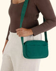 A green crossbody bag made of nylon with an adjustable strap.