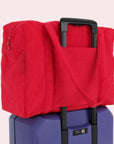 A red nylon carry on tote bag with two handles and a zipper top.