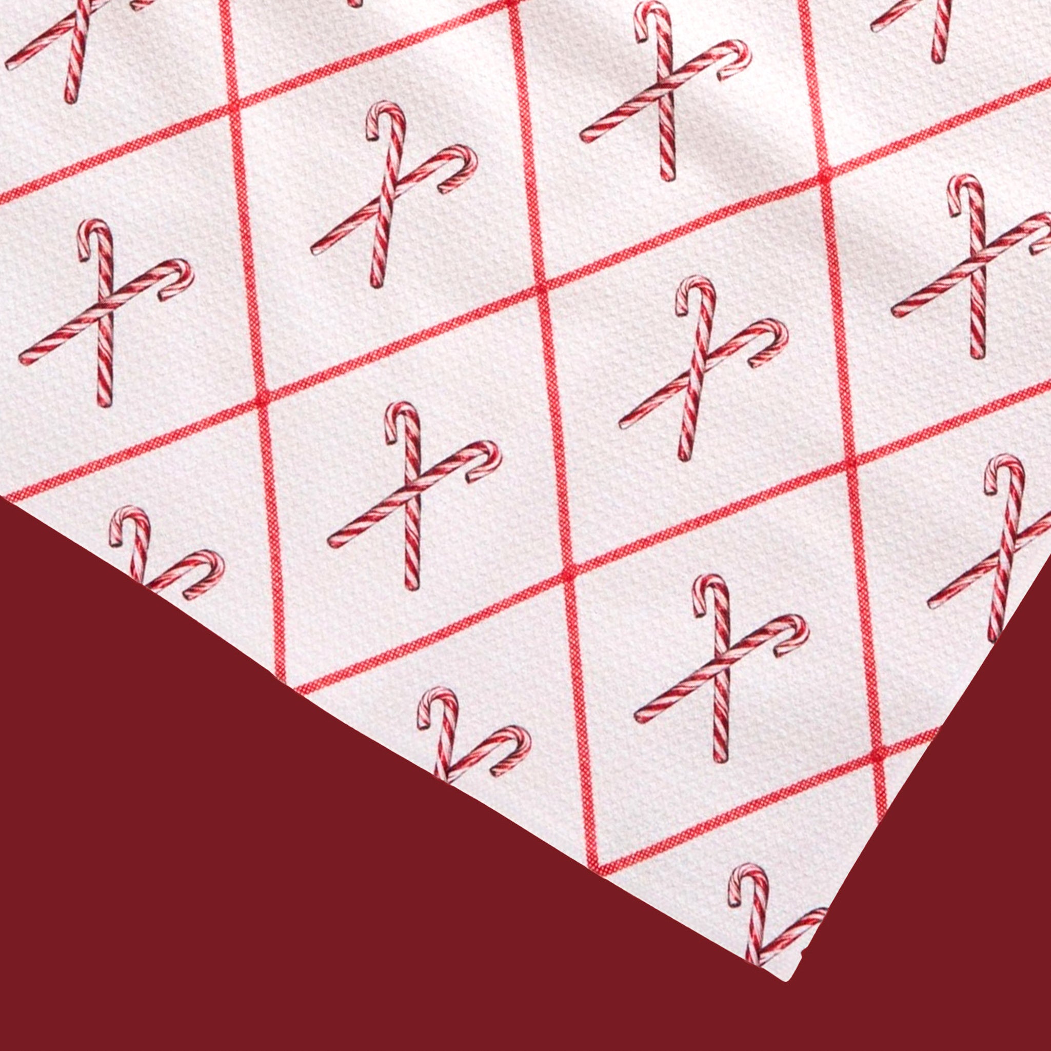 A white tea towel with a red and white candy cane pattern. 