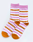 On a white background is pink and orange striped socks. 