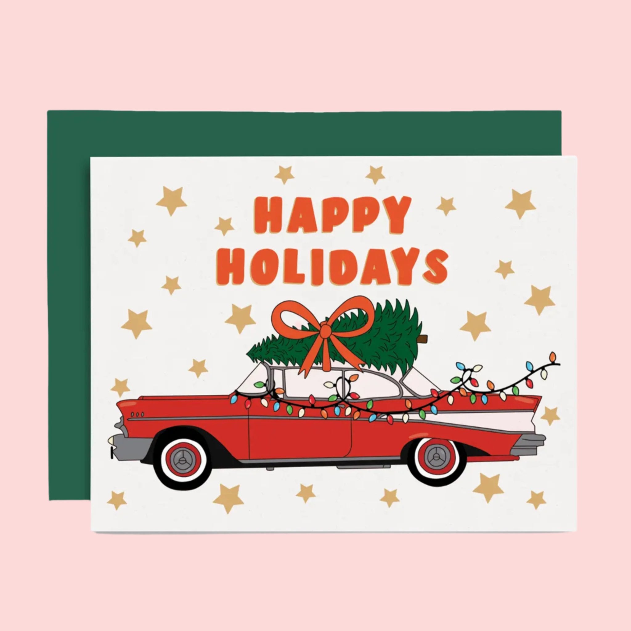 A white, red and green holiday card and envelope with a graphic of a vintage red car with a tree on top and text that reads, 'Happy Holidays'. 
