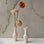 A light pink ceramic bud vase. 