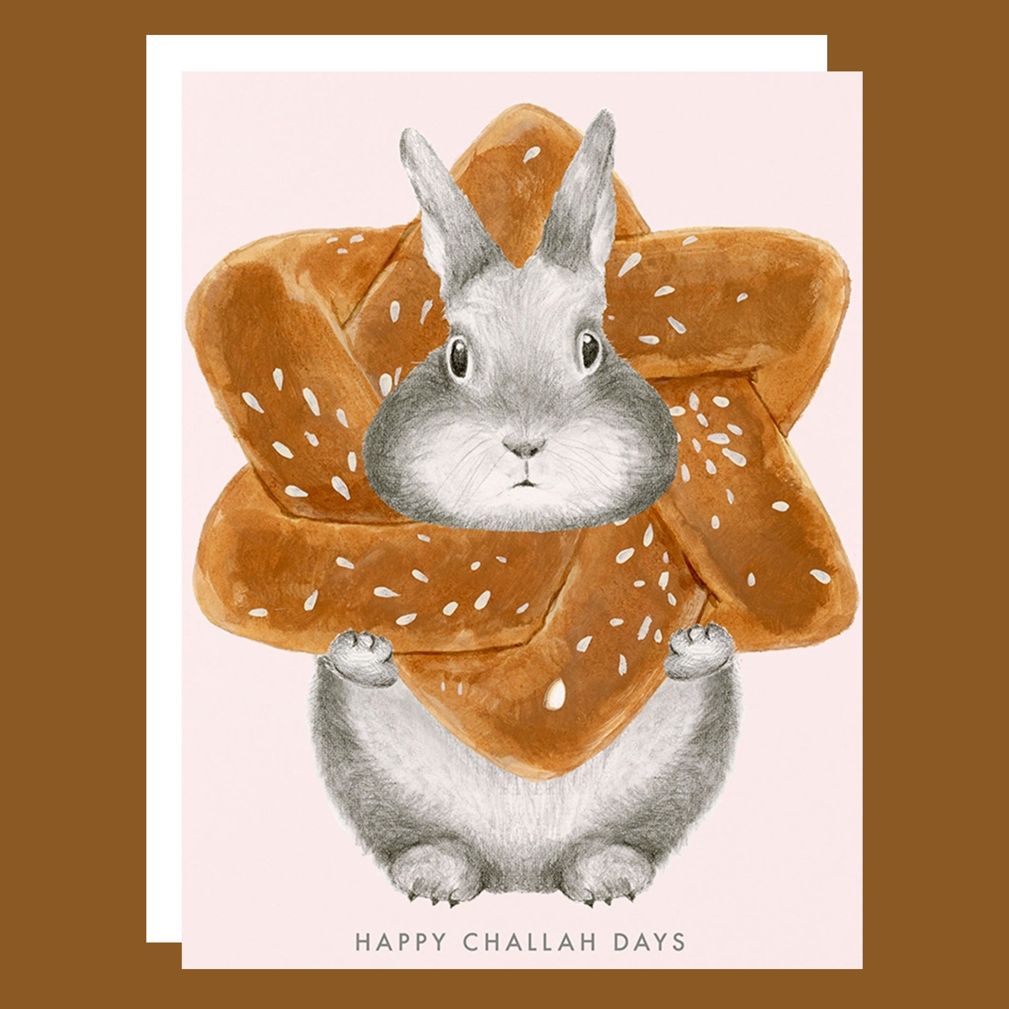 A light pink card with a bunny illustration in the center of a challah bread load and text below that reads, 'Happy Challah Days'. 