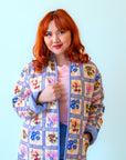 A multi colored quilted jacket with a floral print on one side and a blue solid color on the other. 