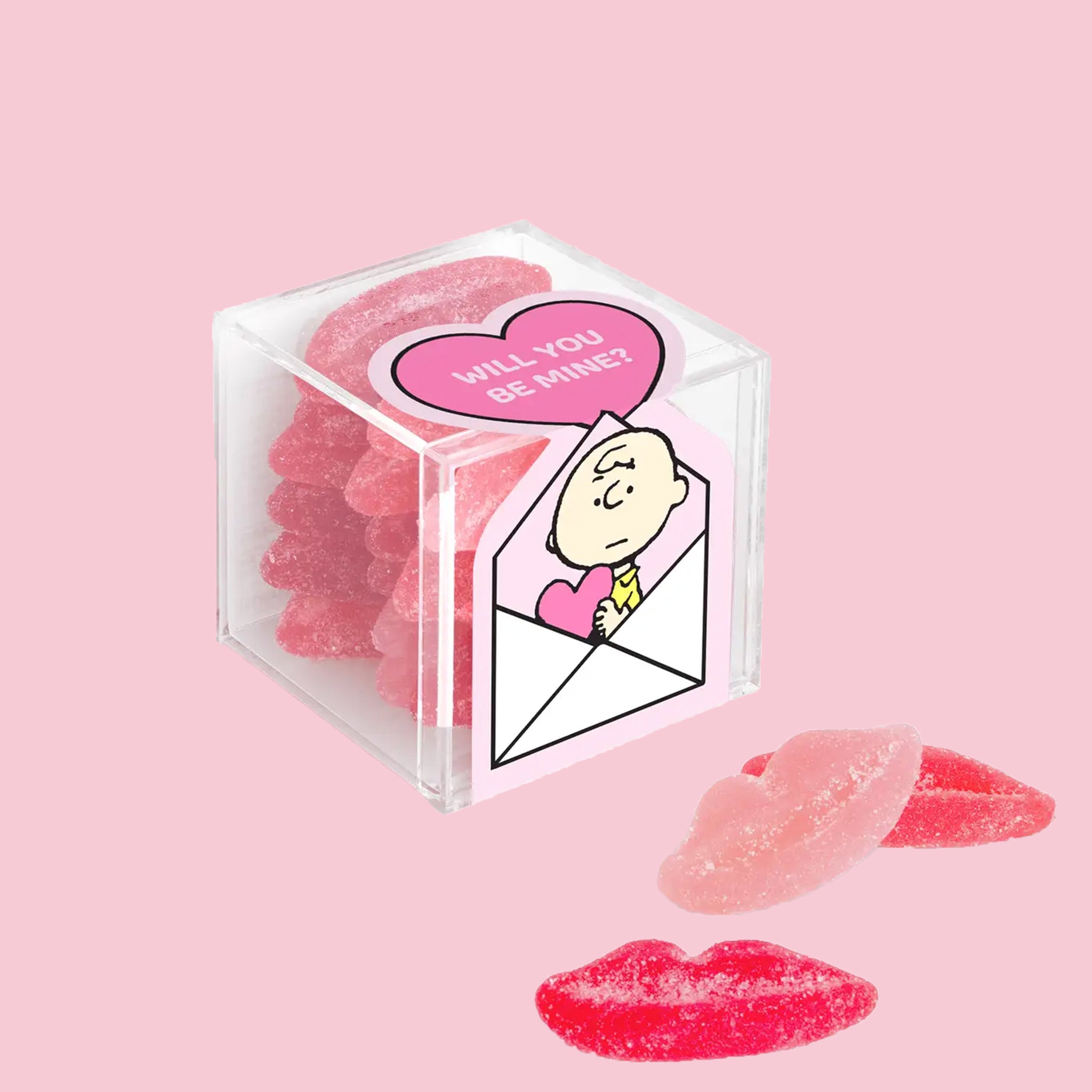 A box of lip shaped sour gummy candies with a label that has a illustration of charlie brown with a heart that reads, "Will You Be Mine". 