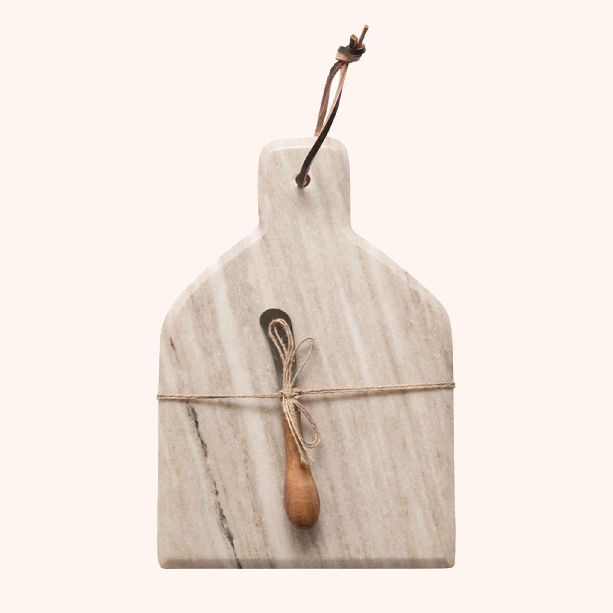 On an ivory background is a tan marble cutting board and knife tied to the center. 
