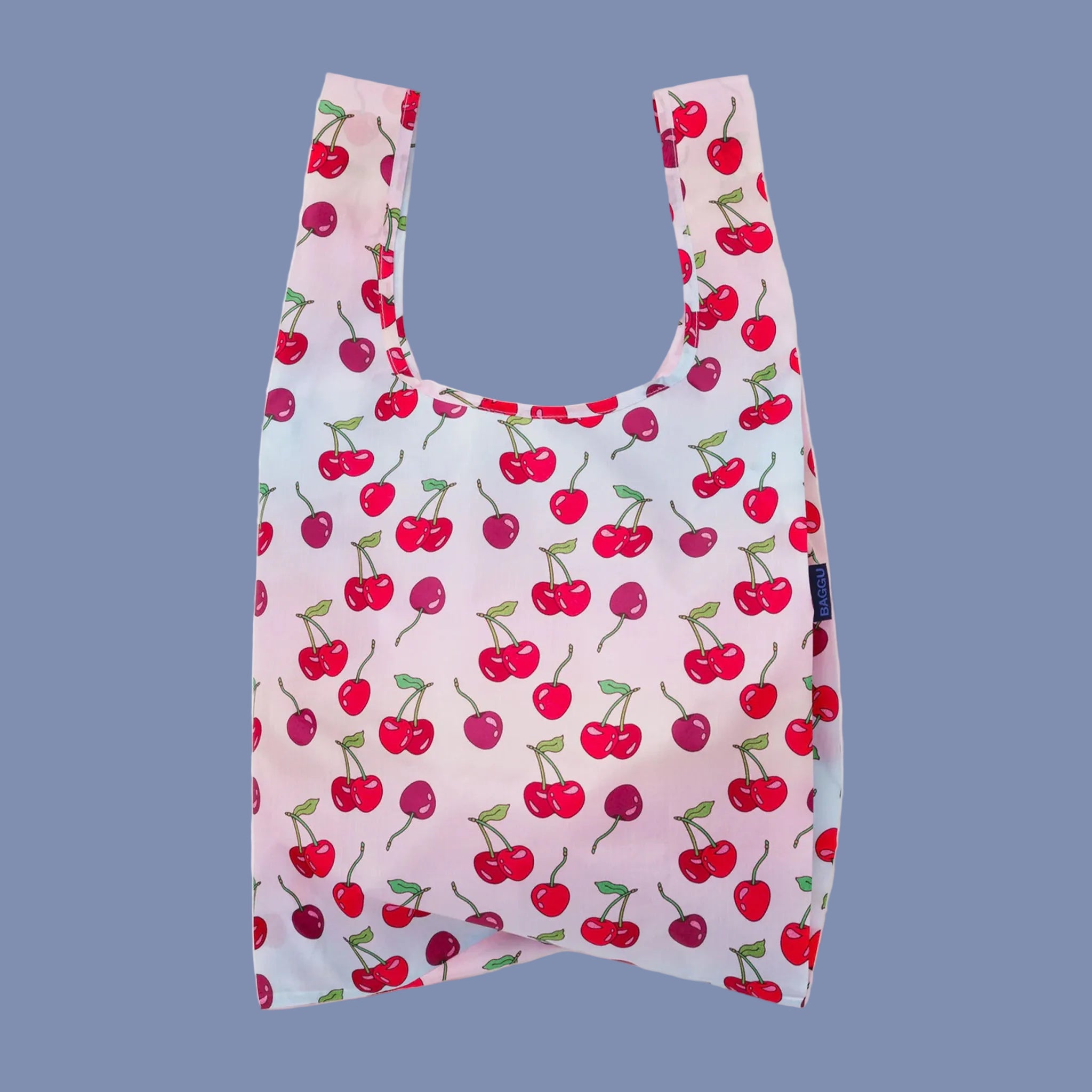 A light pink and blue ombre nylon tote bag with a cherry print. 